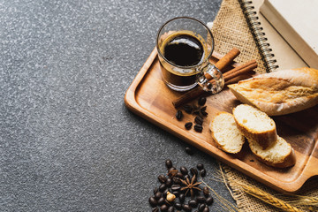 A coffee, bread, wood plate and book setting on black background