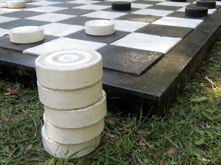 Board with large street checkers on the grass. Intellectual game