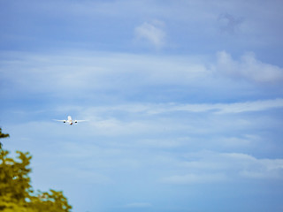 travel and transportation concept from back of aircraft fast fly after take off from runway with blue sky and cloud background