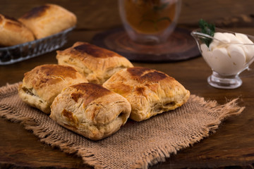 A sweet dessert from slotok with cheese, sour cream sauce, tea from herbs, all on a wooden background.
