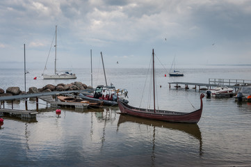 Fototapeta premium View of the harbour of little village. Viking ship in the small harbour. The Gulf of Finland, Estonia. Kasmu (captain's village).