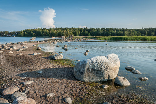 Long and thin peninsula with stones and boulders. The Gulf of Finland shore near Kasmu village in northern Estonia. Sunny. Copy space.
