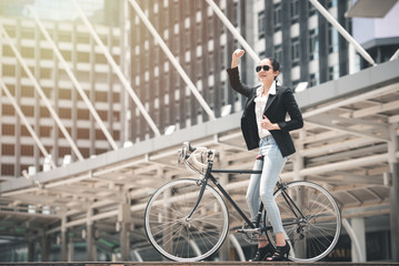 Young Attractive Smart Businesswoman Riding Bicycle on Urban Street to Work in Rush Hour - Eco Friendly and Lifestyle Concept