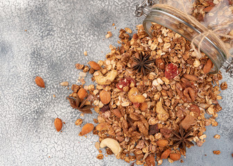 Homemade granola in open glass jar on light background