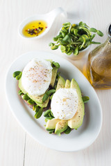 Avocado toast, cherry tomato on wooden background. Breakfast with toast avocado, vegetarian food, healthy diet concept. Healthy sandwich with avocado and poached eggs.