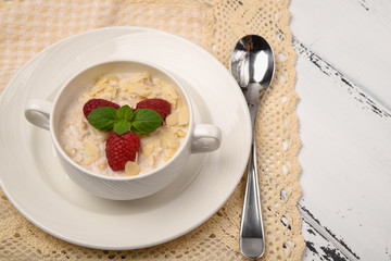 Steel cut oatmeal porridge with raspberry and almond flakes for breakfast