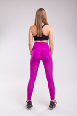 Fototapeta premium Sportive woman wearing sexy leggings. Back view of sporty woman. Rear view of sexual buttocks wearing pink pants leggings.