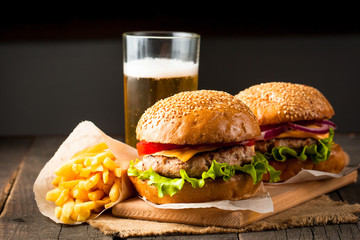 Close-up photo of home made hamburger with beer made of beef, onion, tomato, lettuce, cheese and...
