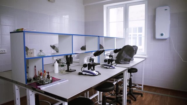 Microscope on table in empty science laboratory. Empty laboratory with microscopes