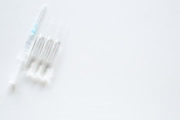 Flu vaccination concept. Syringe and ampoulie on white background top view copy space