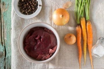 Raw rabbit liver, vegetables and spices for cooking pate or ragout.
