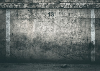A gloomy cracked brick wall with the number 13. Friday the 13th
