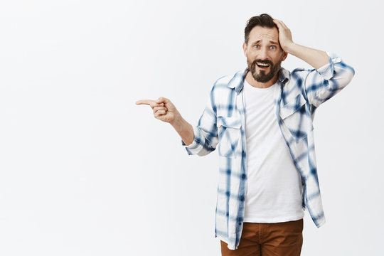 His Car Broke Down, Guy Asking Stranger Take Him To Gas Station. Portrait Of Upset Helpless Handsome Man With Beards, Pointing Left With Index Finger And Holding Palm On Head, Being In Tough Situation