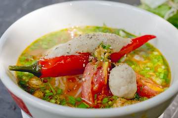 Spicy noodles soup. Noodles with meat ball, chili peppers in bowl. Asian Cuisine Pasta. Top view.