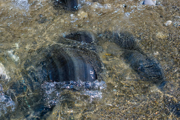 pebble stones on the sea beach, the rolling waves of the sea with foam