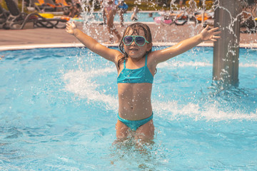 Fototapeta na wymiar little girl playing in the swimming pool