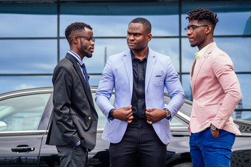 A group of three African Americans business men in stylish suits communicate discussion with each...