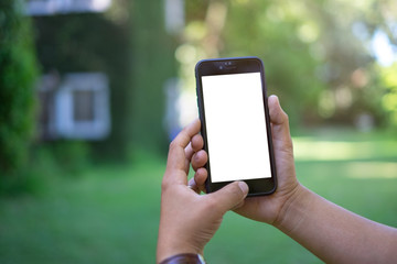 Mock up smartphone blank screen in man hands in the garden blurre background.