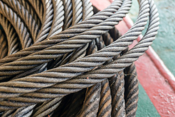 Wire rope sling being used as anchor pennant wire coiled on deck of a construction barge at oilfield