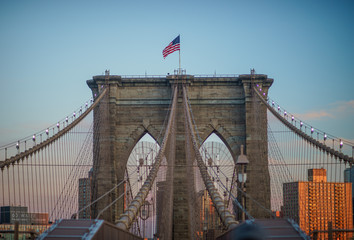 Close up view of one of the towers structures of the brooklyn bridge, flying the Stars and Stripes on the top