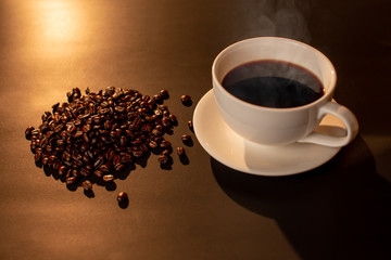 Coffee cup with coffee bean in golden light.