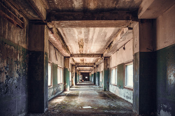 Fototapeta premium Dirty empty dark corridor in abandoned building, perspective