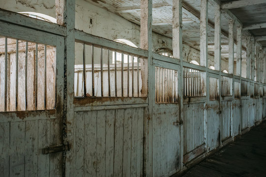 Inside old wooden stable or barn with horse boxes, corridor