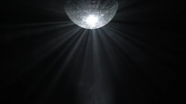 Silver mirror disco ball rotating in black space