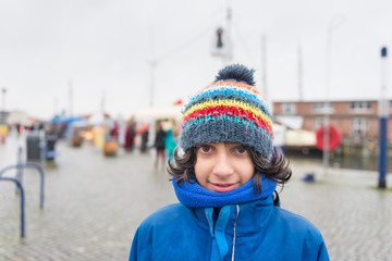 Child with bobble cap on cold day in city