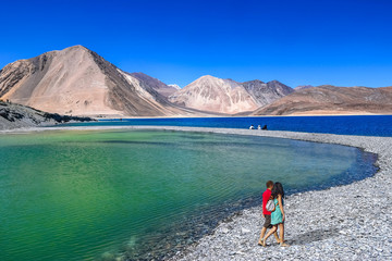 Couple enjoy a romantic moment at scenic Pangong lake Ladakh, India.