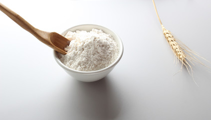 flour glass wooden spoon ears on a light background