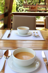 Two plates of hot soup on a summer terrace