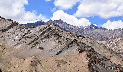 Helicopter flies over Ladakh mountain ranges with tourists on sightseeing tour