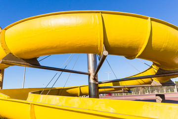Naklejka premium Amusement Yellow Water Slide Park Closeup
