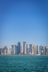Fototapeta na wymiar The skyline of Doha, Qatar, on a blue sky day, winter time, seen from the MIA Park