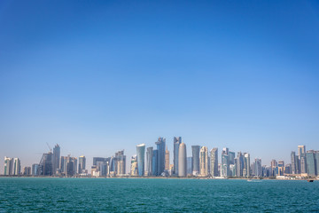 Obraz na płótnie Canvas The skyline of Doha, Qatar, on a blue sky day, winter time, seen from the MIA Park