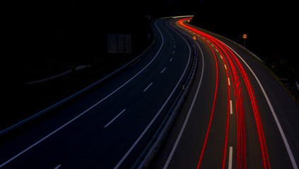 Fototapeta na wymiar Car lights on a mountain road at dusk