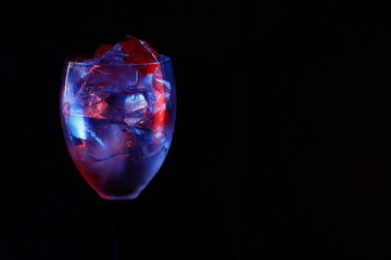 Ice in a glass with raspberry red and blue highlight.