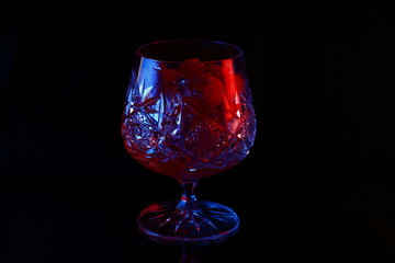Ice in a glass with raspberry red and blue highlight.