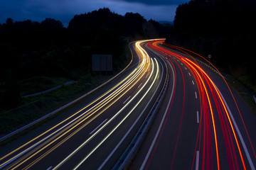 Fototapeta na wymiar Car lights on a mountain road at dusk