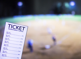 Bookmaker ticket on the background of the TV on which show a sports game softball, sports betting,...
