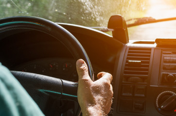 The driver's hands on the steering wheel of the car