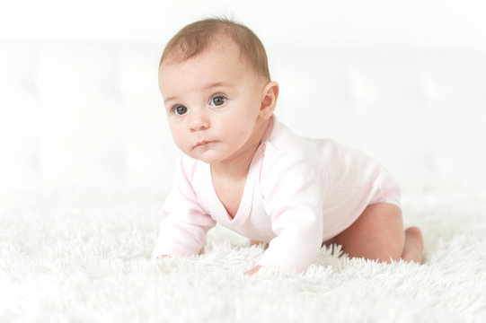Portrait of a cute baby girl on light background