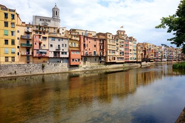 Fototapeta na wymiar Multicolored old houses on the embankment of the river Onyar in the Catalan town of Girona