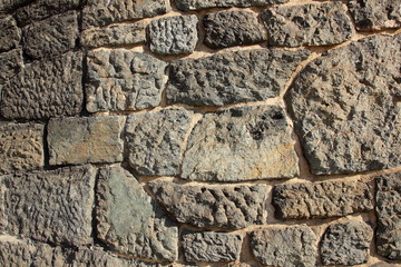 Fototapeta premium Ancient wall of the medieval city, the wall of an ancient temple in Prague, stone masonry test with cement, blank for designer, retro background