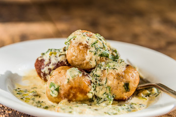 Swedish food - traditional chicken meatballs with creamy sauce on a rustic background, close-up