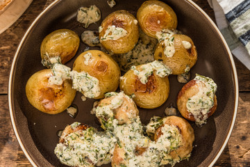 Swedish food - traditional chicken meatballs with cream sauce and new potatoes on a rustic wooden background