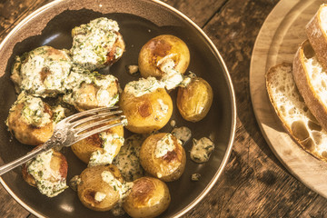 Swedish food - traditional chicken meatballs with cream sauce and new potatoes on a rustic wooden background