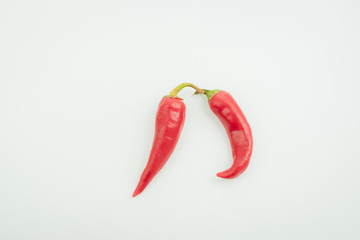 Two chili peppers on a light background