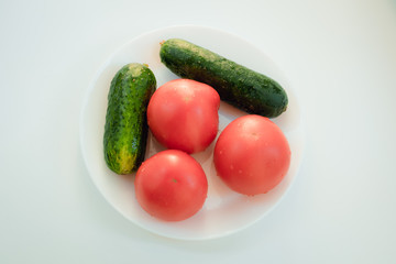 Cucumbers and tomatoes on a white plate